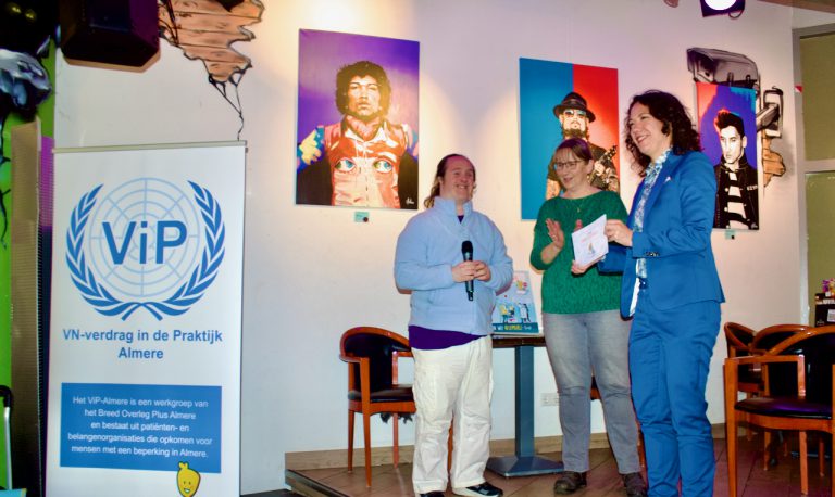 Drie mensen voor uitreiking Guusje Boekje 2 aan de wethouder